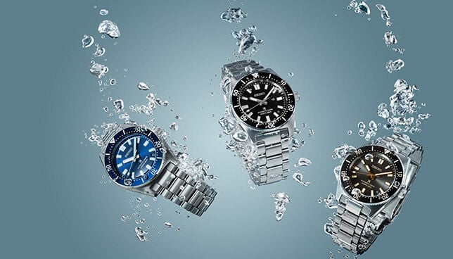 Seiko Prospex diver’s watches in blue, black, and brown dials submerged underwater, showcasing water resistance and durability